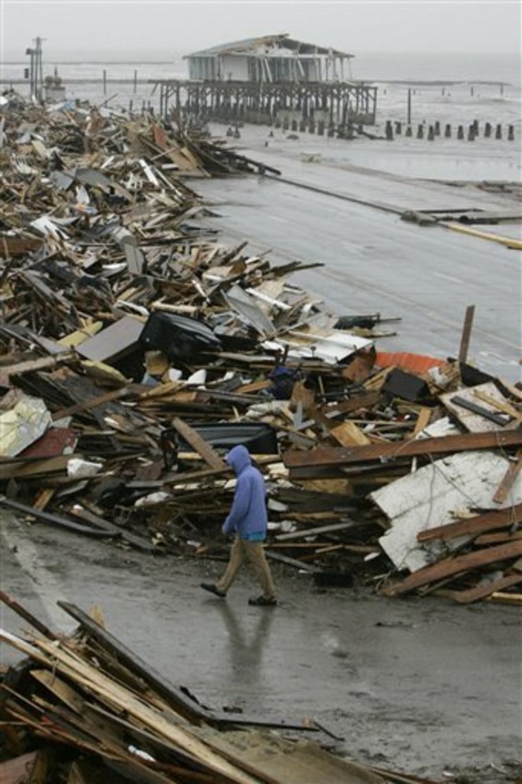 A man walks past debris piled up on the seawall road after Hurricane Ike hit the Texas coast, in Galveston, Texas, in this Sept. 14, 2008 file photo.